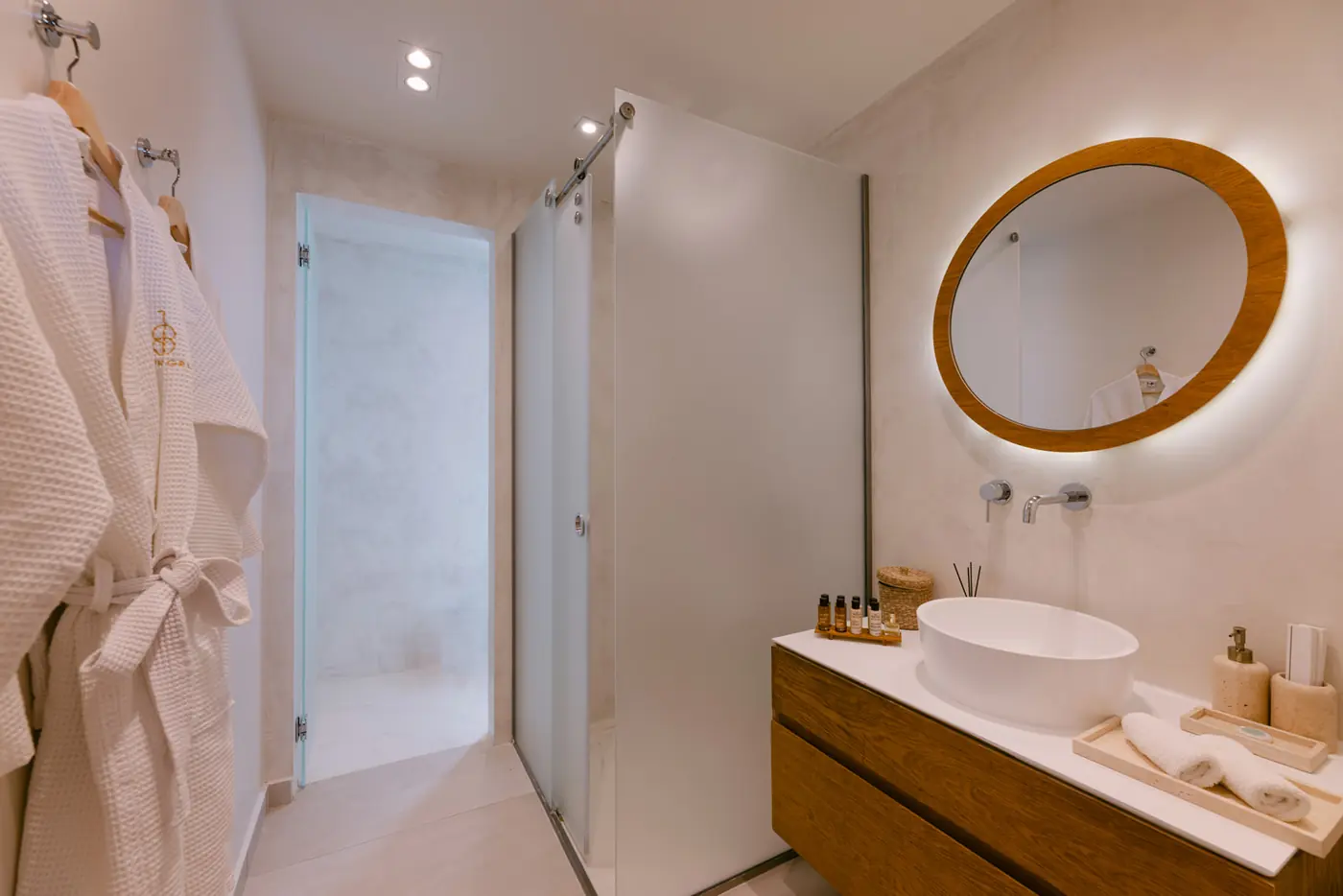 18 Grapes: Basin on a wooden vanity with a lit mirror