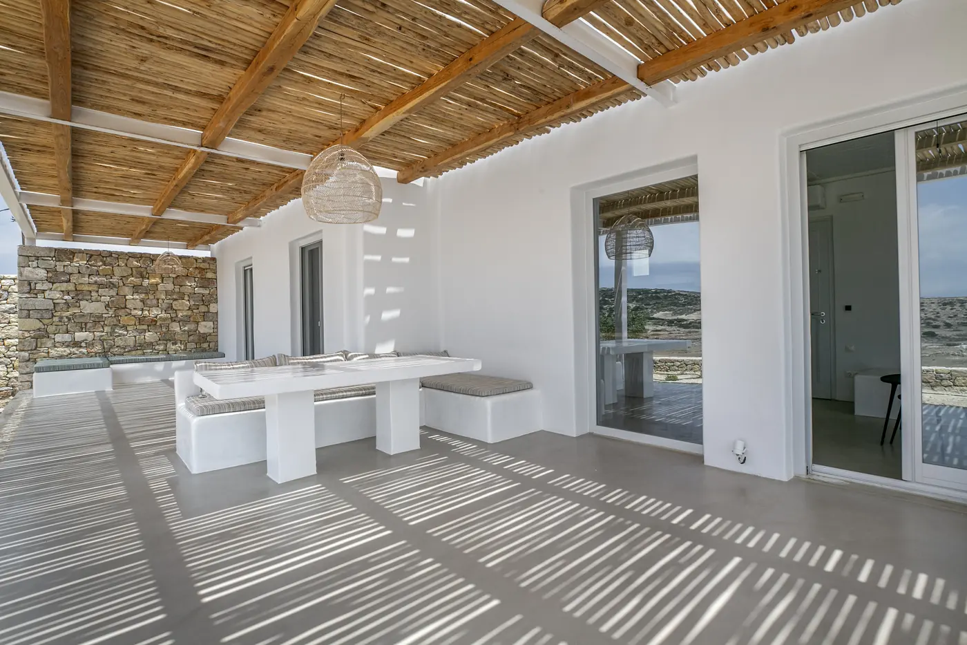 Momi Homes: Covered terrace with a reed roof and a built-in table