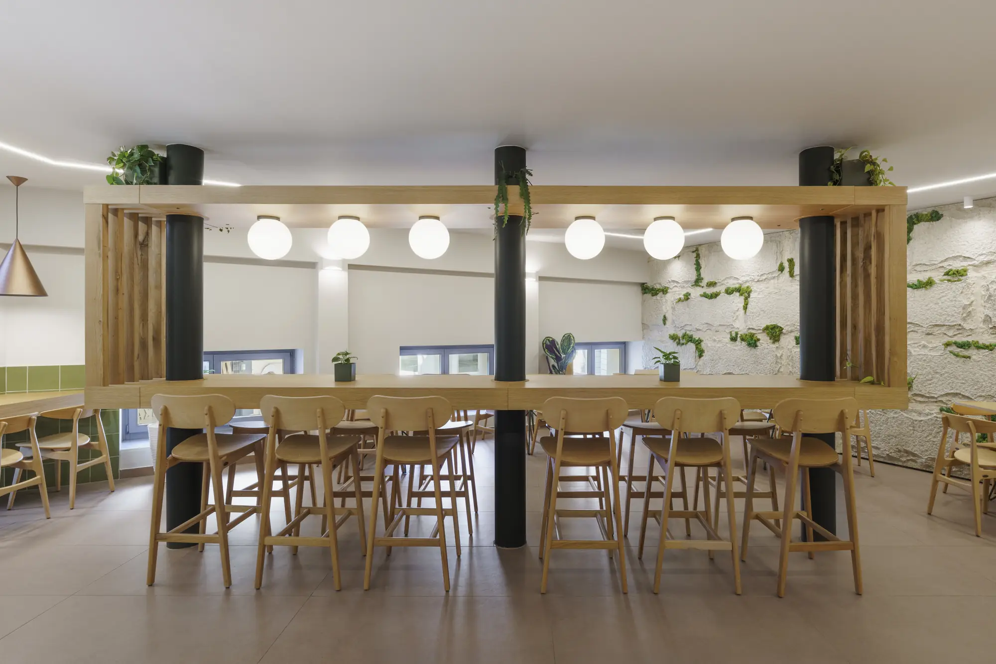 The dining room with the long shared table and globe lights